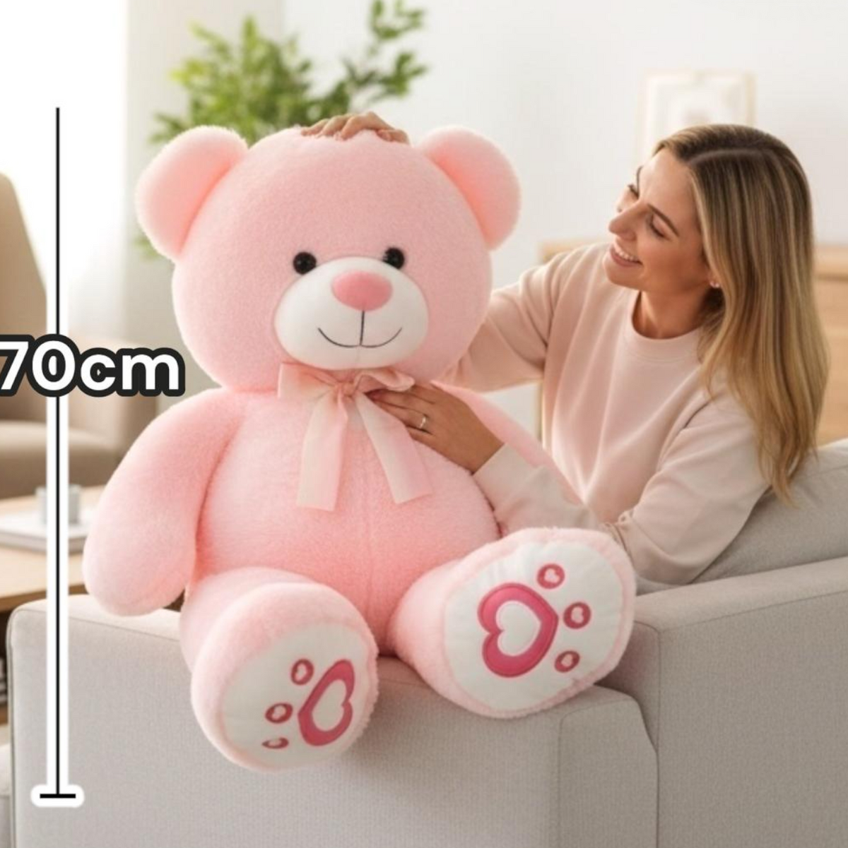Pink huggable teddy bear with a cream satin bow and heart printed paw pads