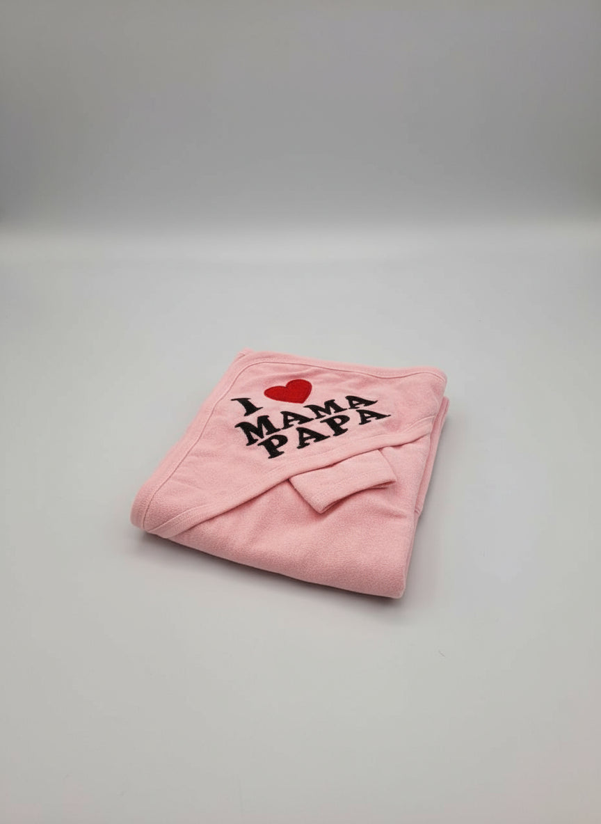 Pink hooded baby towel folded neatly with a red heart and bold black mama and papa lettering