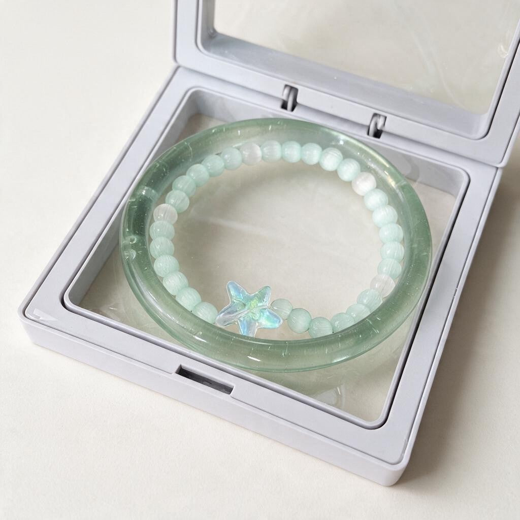 Frosted green jelly bangle with a mint bead bracelet and blue star charm in a display box