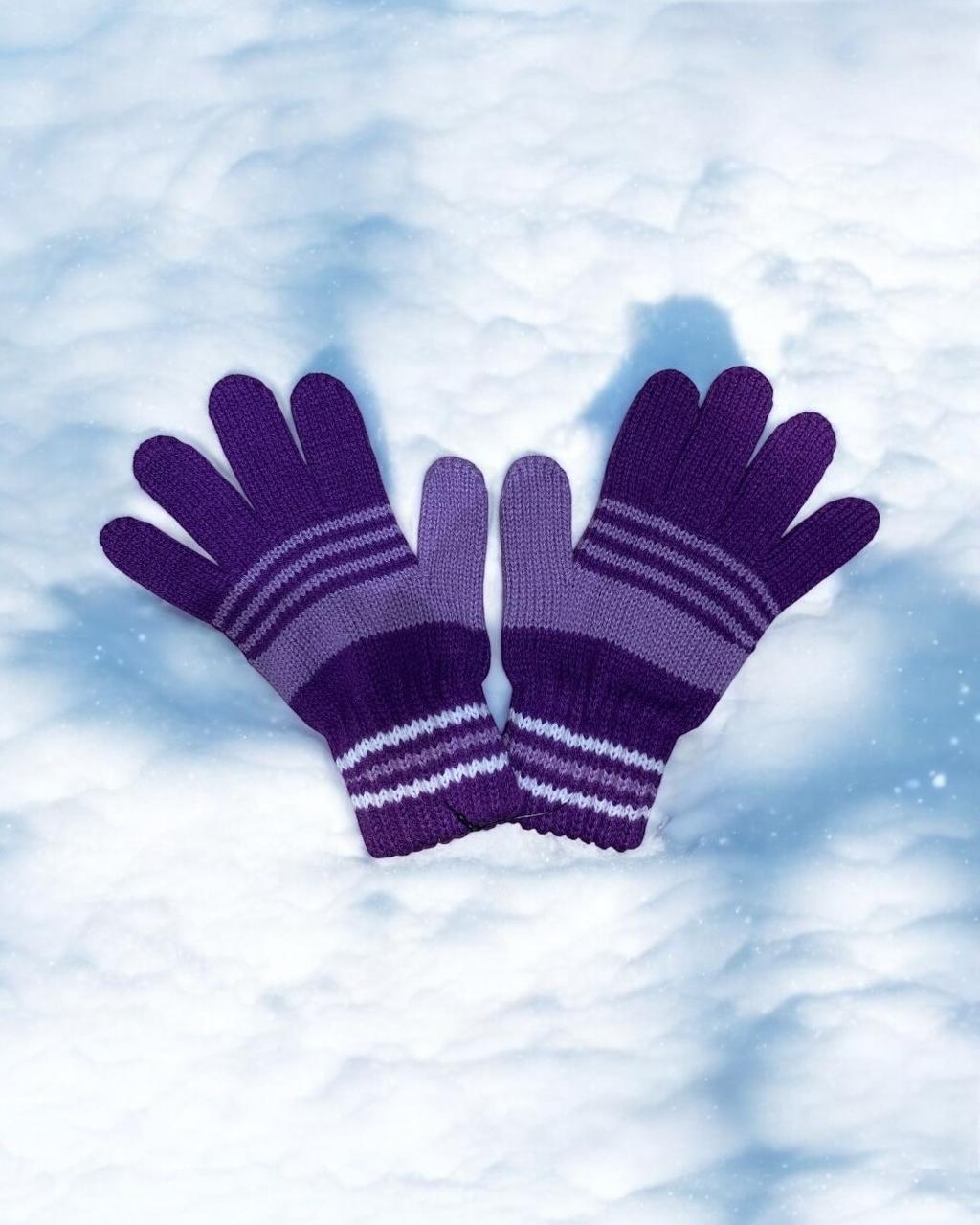Purple gloves with lilac and white striped cuffs on snow