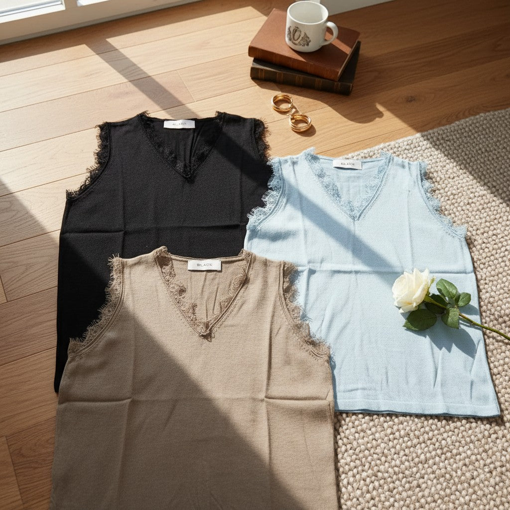 Three sleeveless knit tops with lace trim in black, light blue and beige laid flat