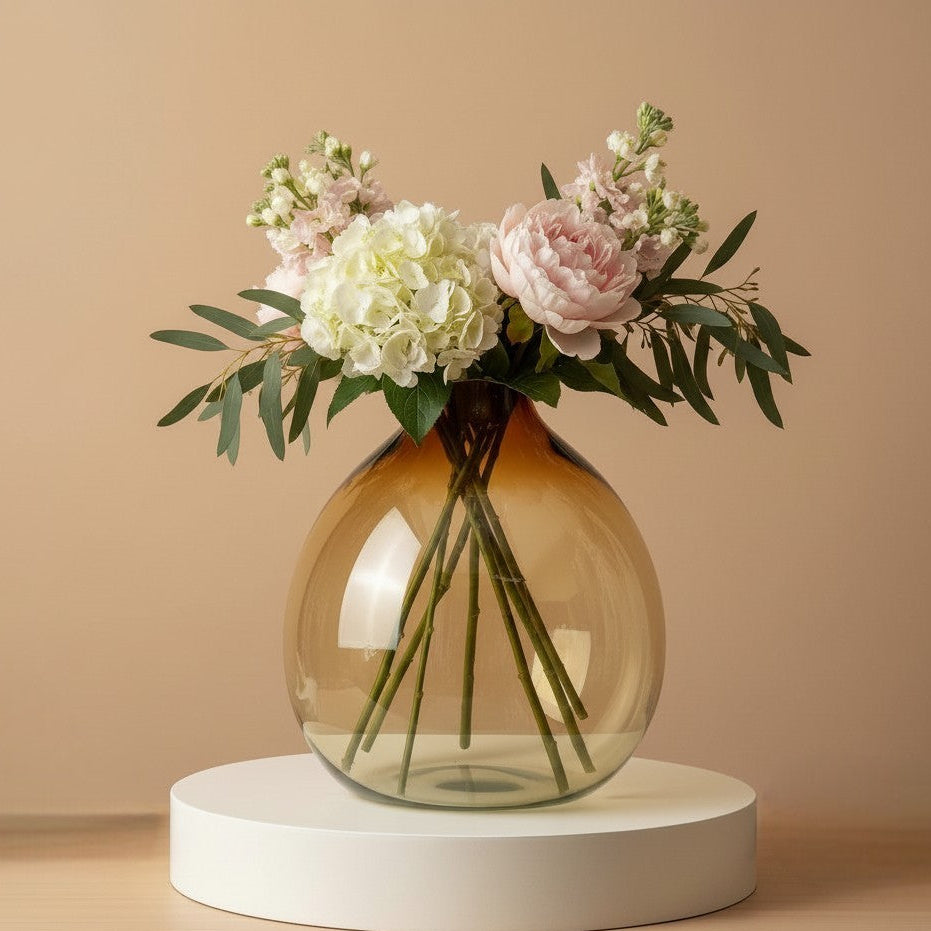 Large balloon round amber vase filled with hydrangea, peonies and eucalyptus