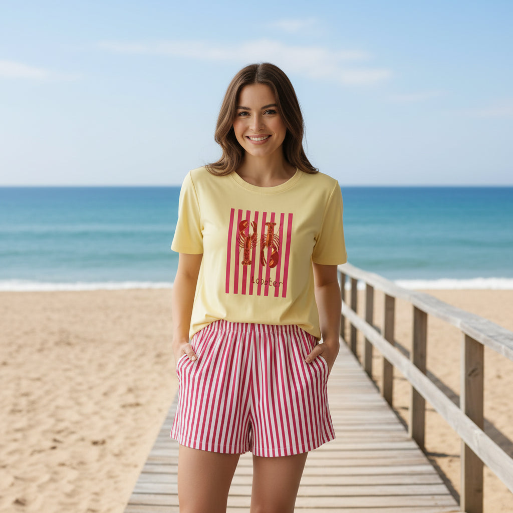 Yellow t-shirt with red graphic and red striped shorts on a dark surface