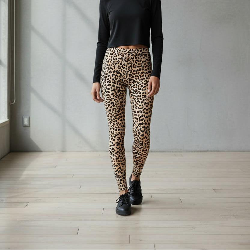 Person wearing leopard print leggings and black top in a minimalistic room