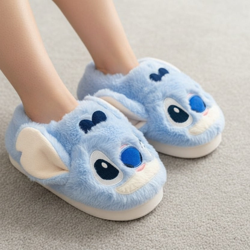 Blue cartoon slippers with a stitch face design on a neutral background