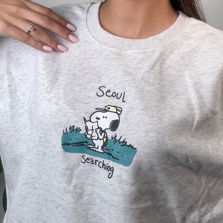 Close up of the puppy scout print and lettering on a light grey heather sweatshirt