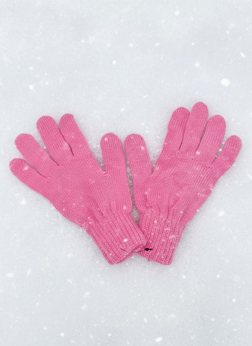 Pair of plain light pink knitted kids gloves on fresh snow