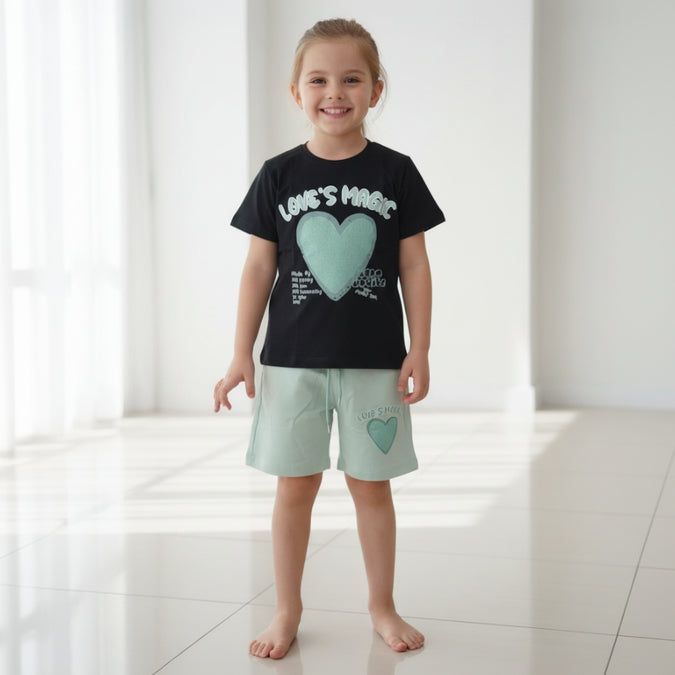 Girl in a black heart print tee and mint green shorts