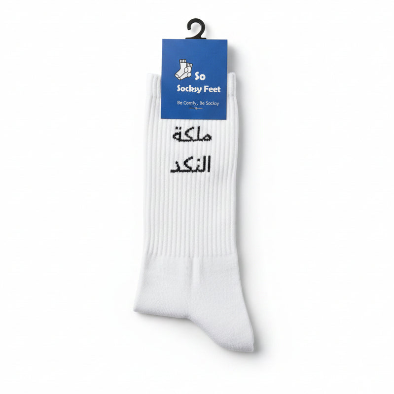 White crew socks knitted with bold black Arabic lettering across the cuff