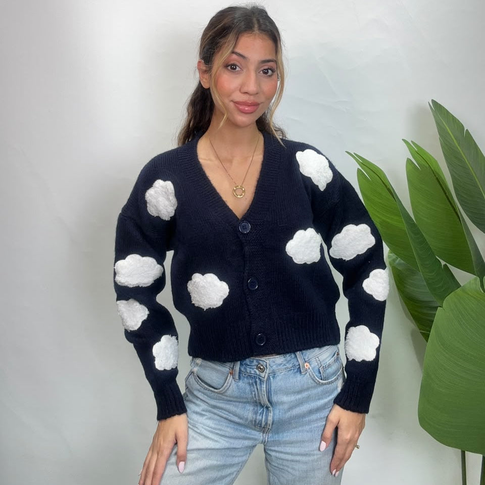 Navy V neck cardigan with white cloud patches on the body and sleeves, worn with light jeans
