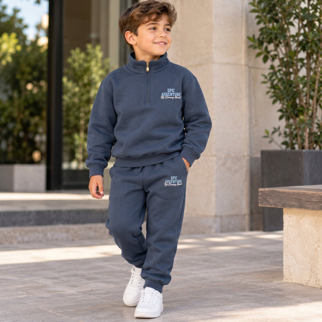 Boy walking in a navy half zip sweatshirt and jogger set with Epic Adventure print and white sneakers
