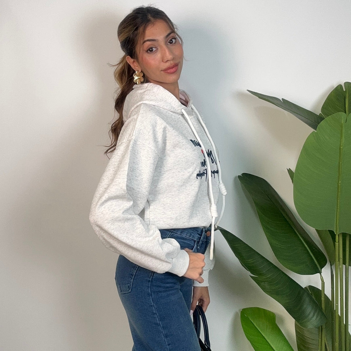 Side view of the oatmeal cropped hoodie showing the relaxed sleeve and hem