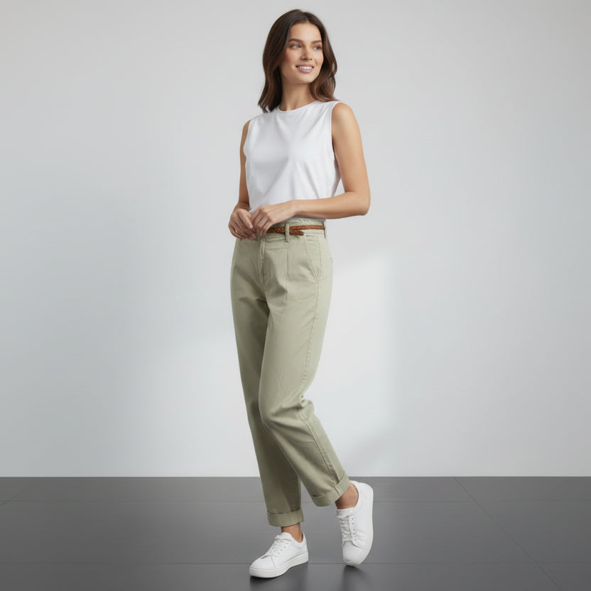 Person wearing olive green pants and white sneakers on a gray floor with white background