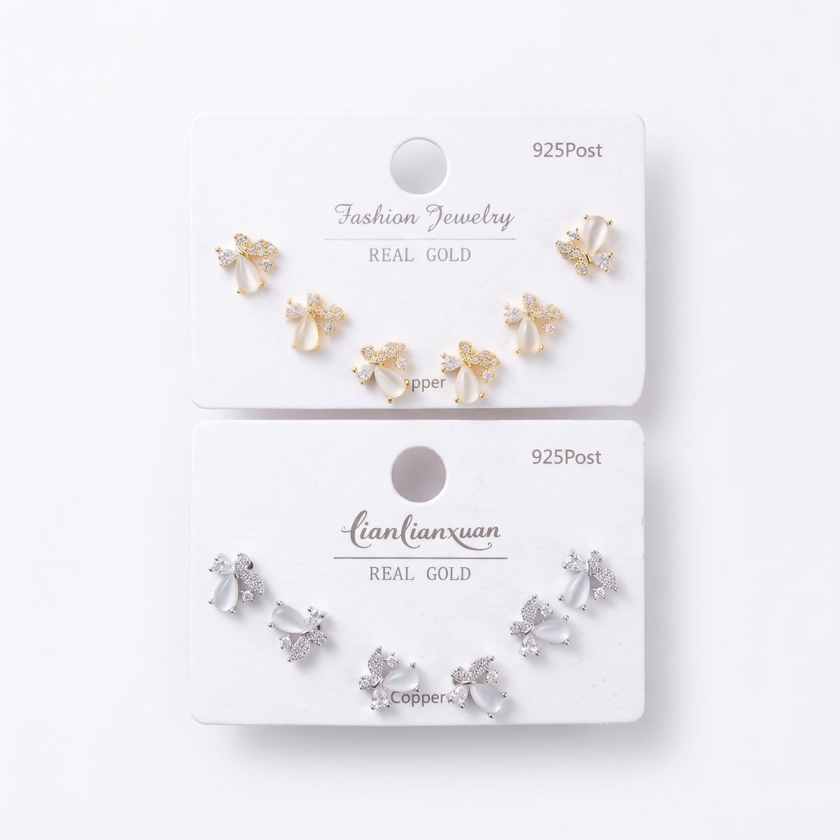 Opal petal stud earrings with cubic zirconia wings shown on gold and silver cards