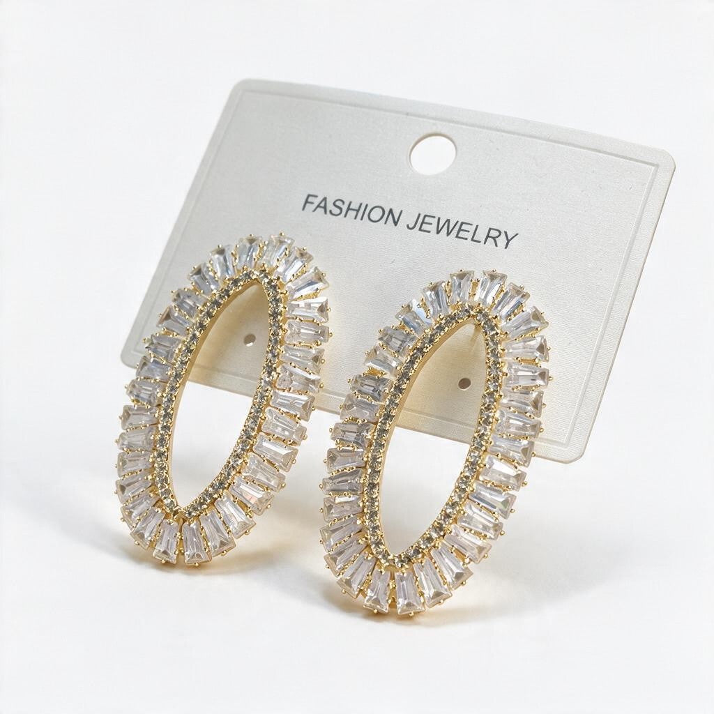 Gold open oval earrings with clear baguette stones and a pave inner edge on a card