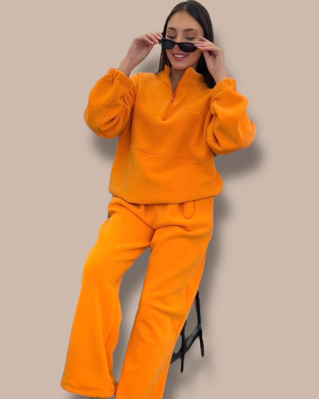 Person wearing an orange outfit against a beige background