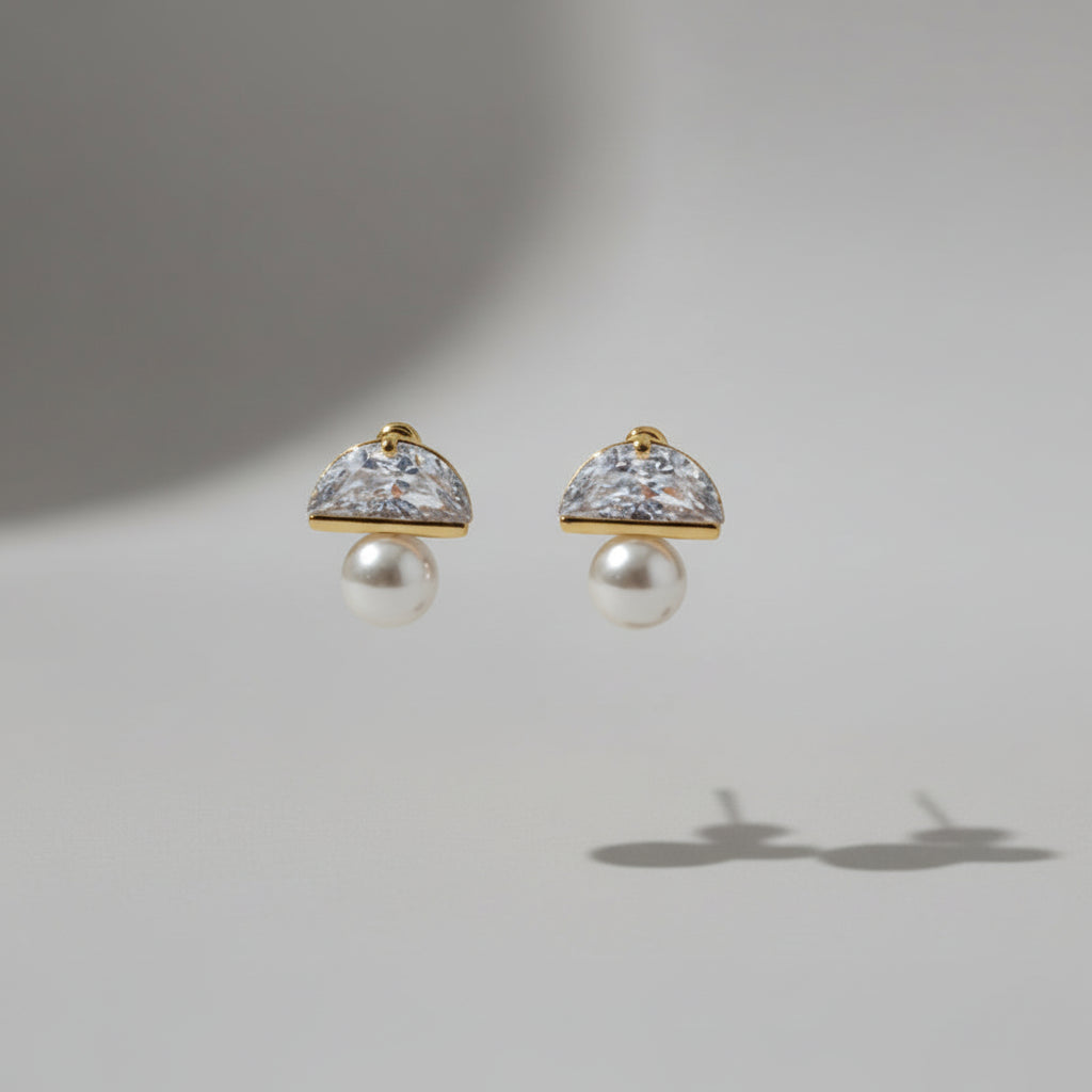 Pair of earrings with pearl-like centers on a light grey background