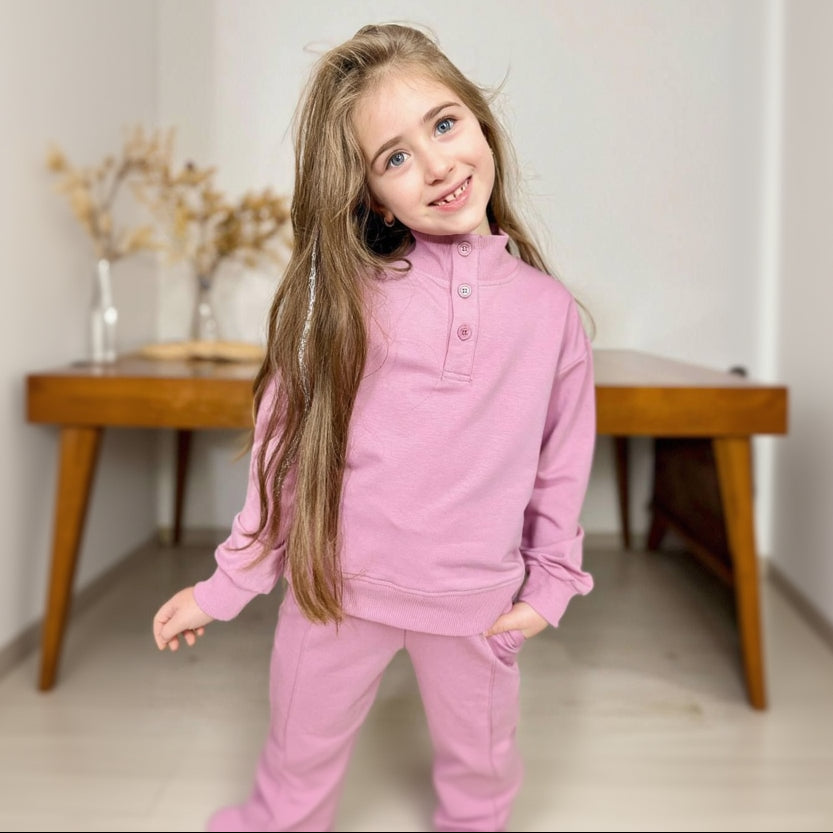 Girl in a dusty pink button placket sweatshirt and matching pants