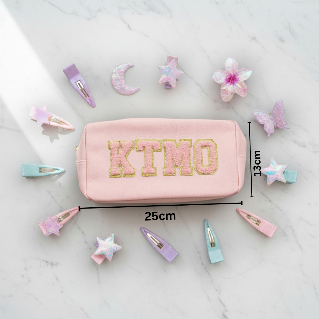 Pink pouch with 'KTMO' branding with measurements 13x25cm on a white background with hair accessories