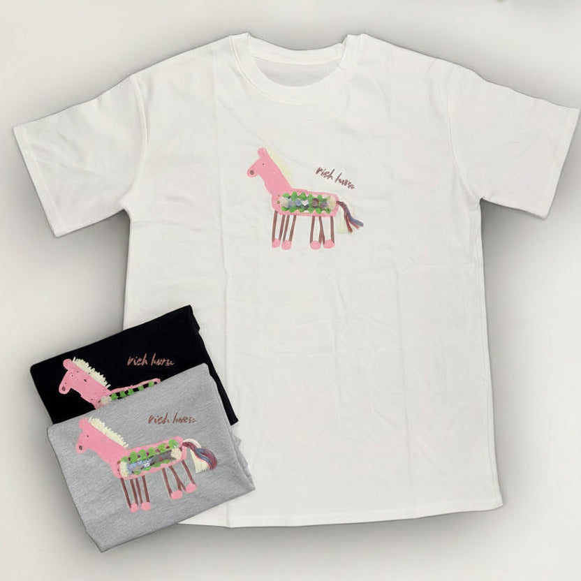White t-shirt with pink llama design on a white background