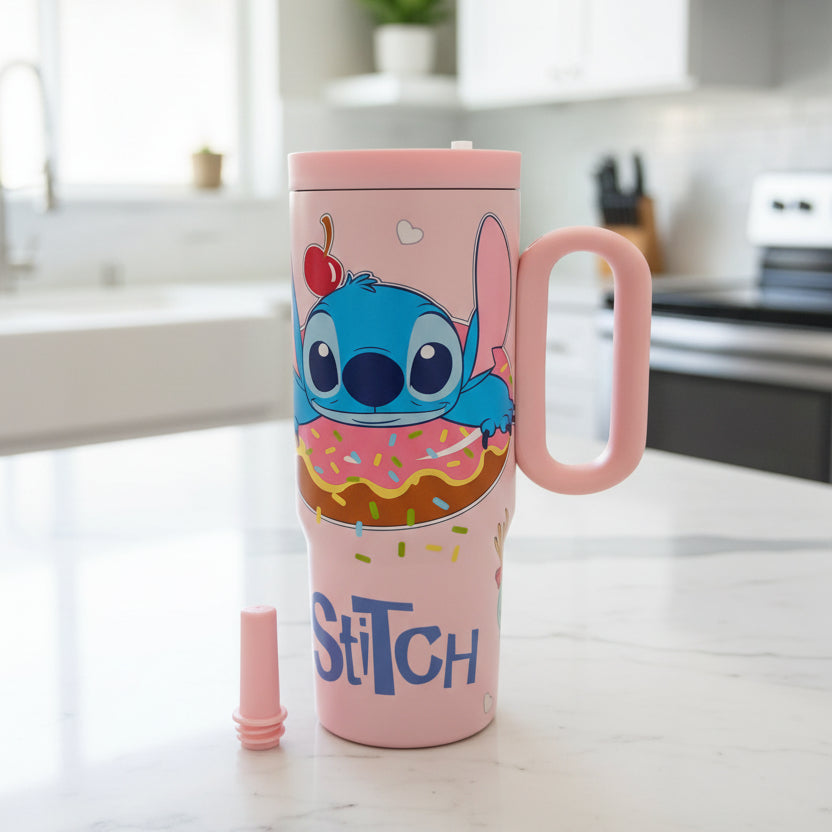 Pink Stitch tumbler with the straw stopper removed on a marble counter