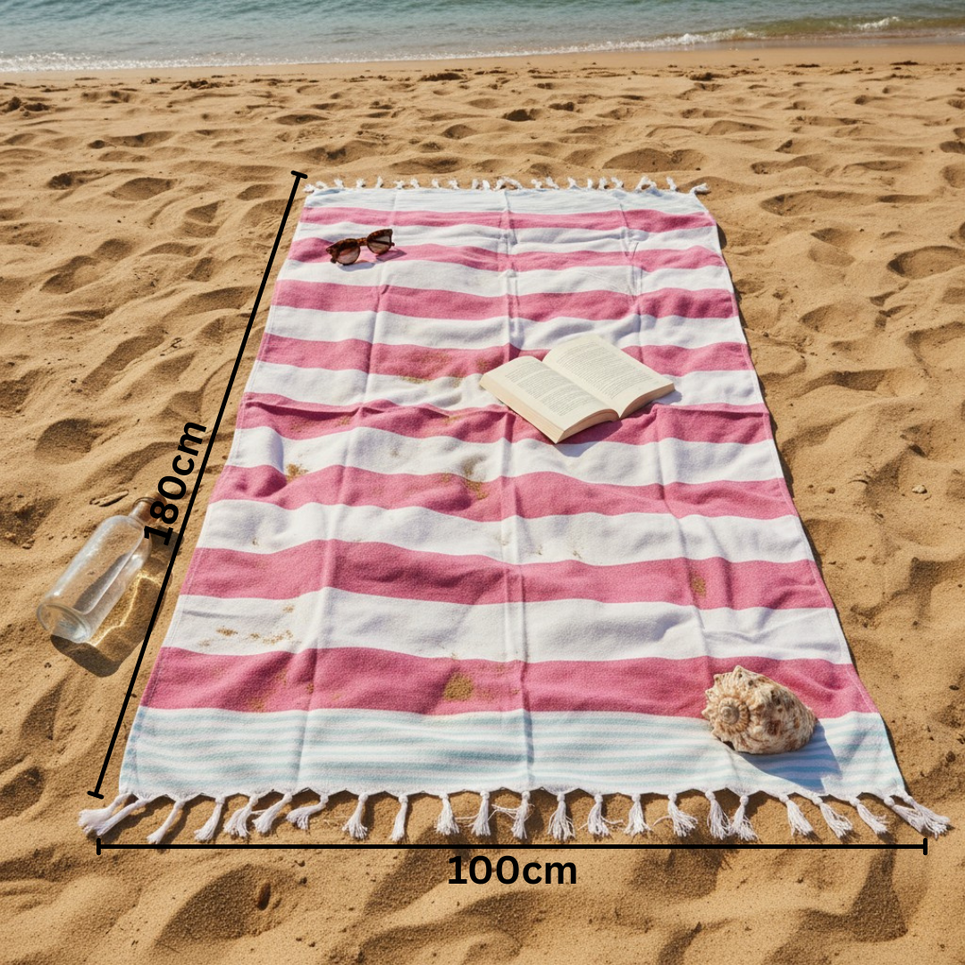 Pink and white striped beach towel on a sandy beach with measurements indicated.