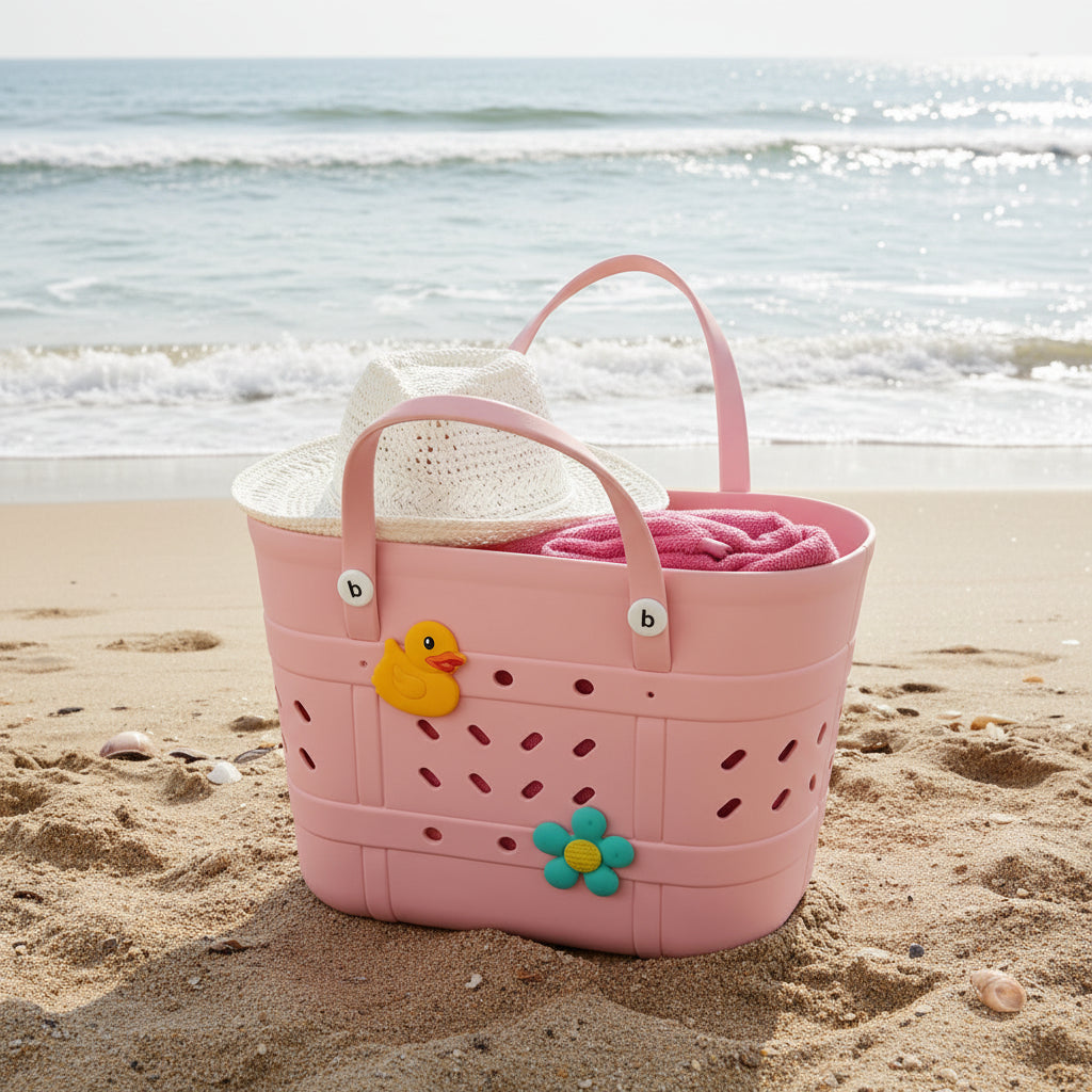 Pink crocs beach bag with a rubber duck and flowers on the beach, with a hat and towel in it.