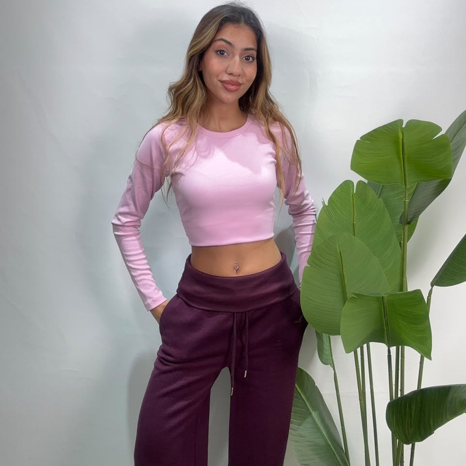 Front view of plum drawstring sweatpants with relaxed wide legs worn with a pink crop top
