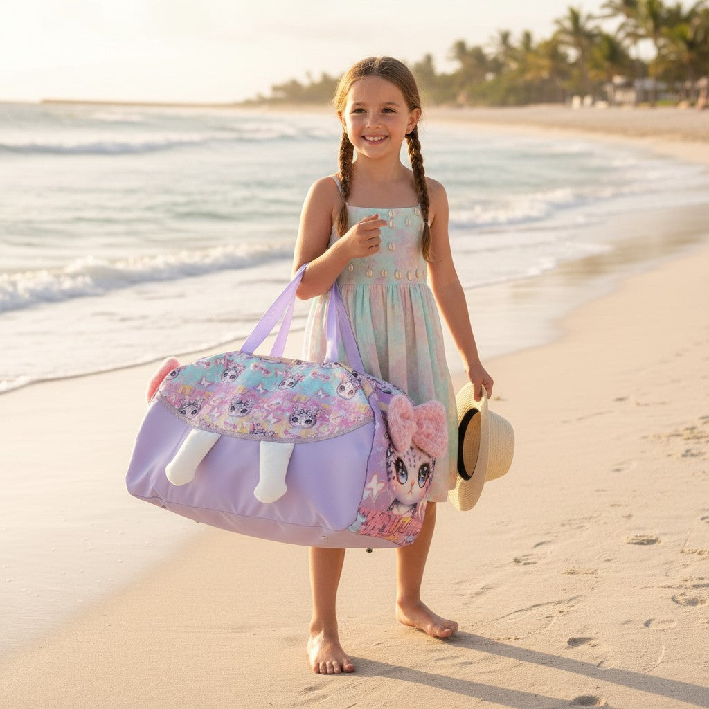 Girl in a pastel dress holding a lilac plush kitten duffle bag and a straw hat on the beach