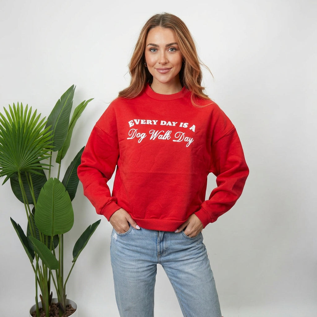 Close up of a red sweatshirt with a white Every Day Is A Dog Walk Day print and ribbed cuffs