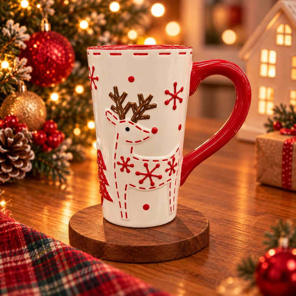 Tall white ceramic mug with a raised reindeer, red snowflakes and a glossy red handle