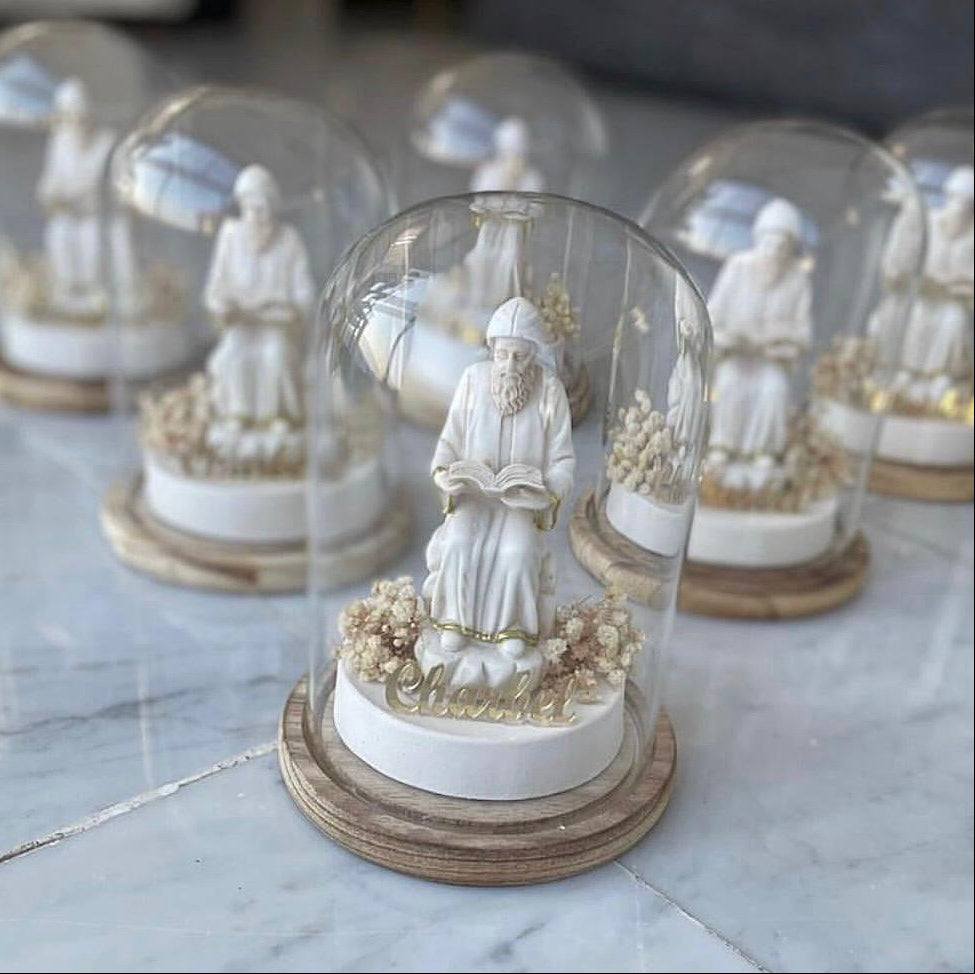 Full length standing monk holding an open book under an unribboned glass dome
