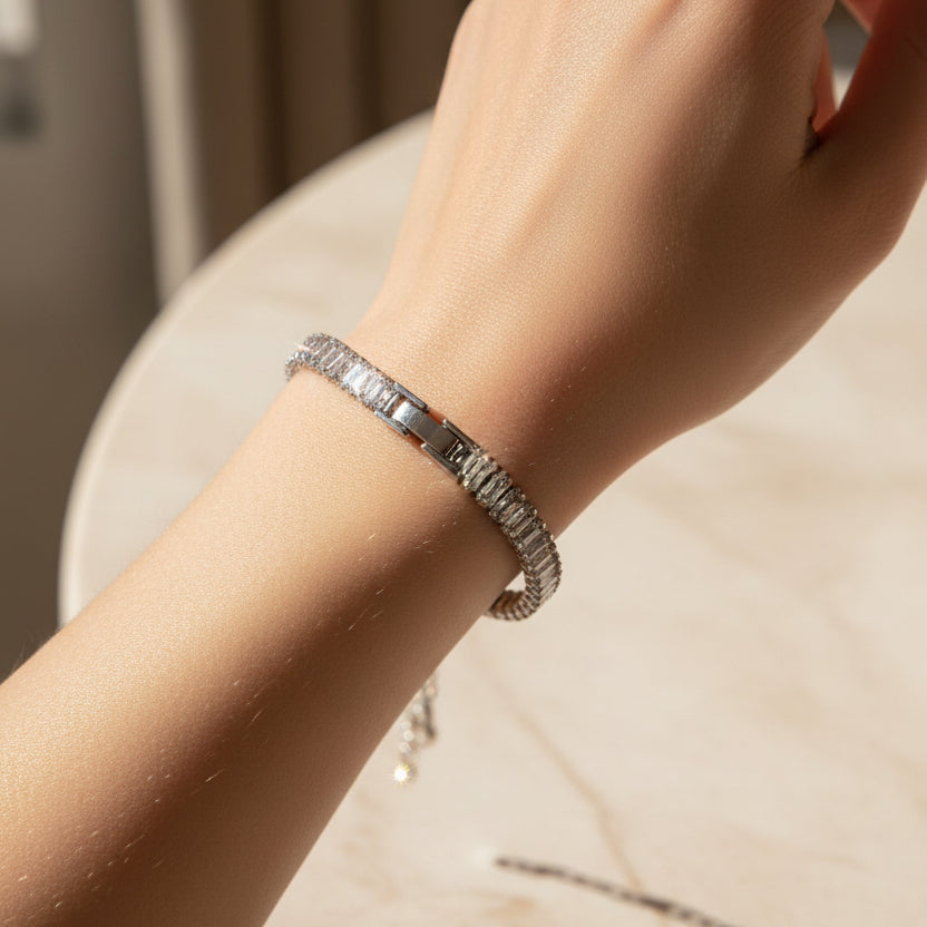 Silver baguette tennis bracelet with clear stones on a person's hand