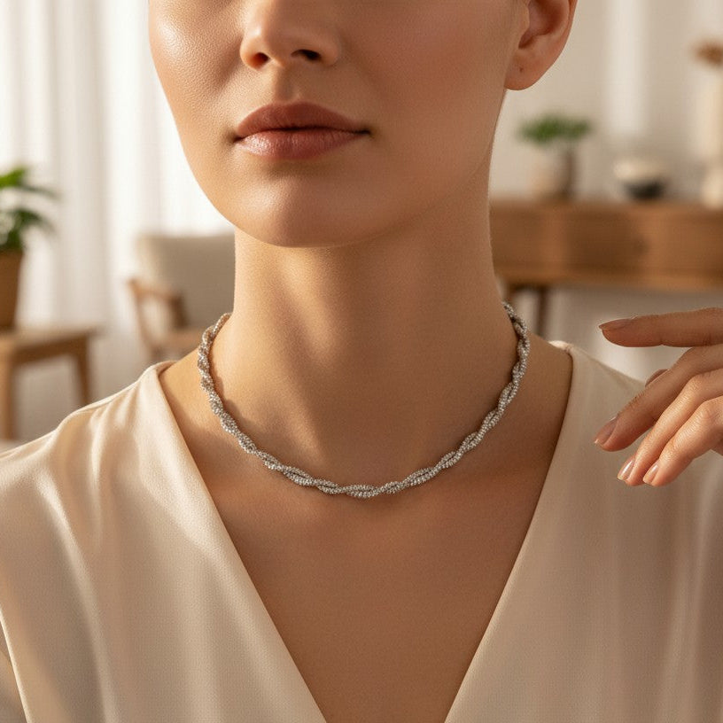 Woman wearing a silver necklace in a softly lit room