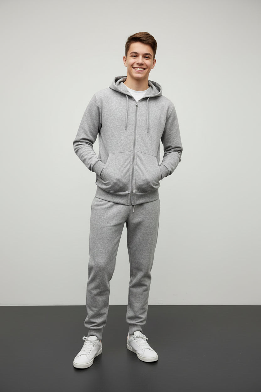 Teenage boy in a grey zip up hooded jacket and matching grey joggers with white sneakers