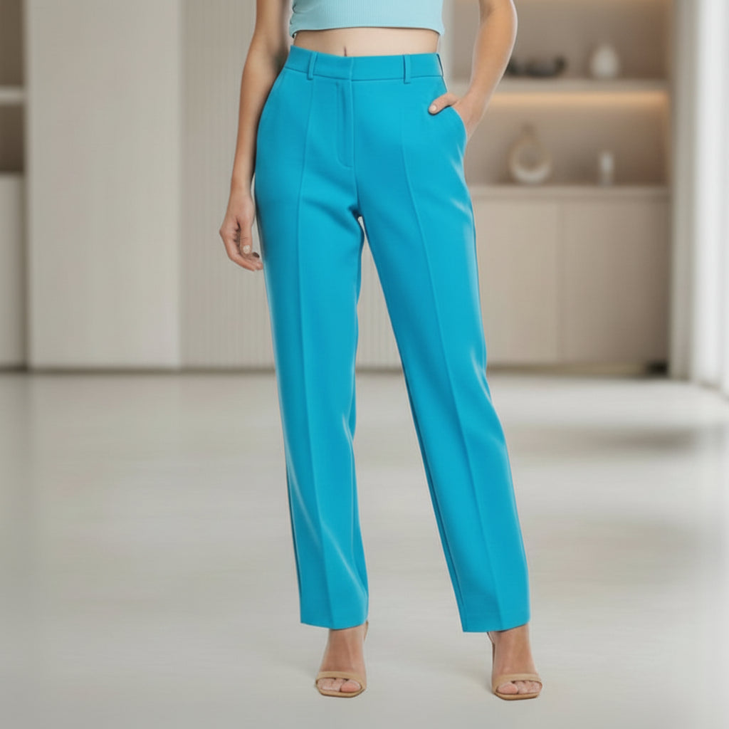 Person wearing turquoise pants in a minimal indoor setting