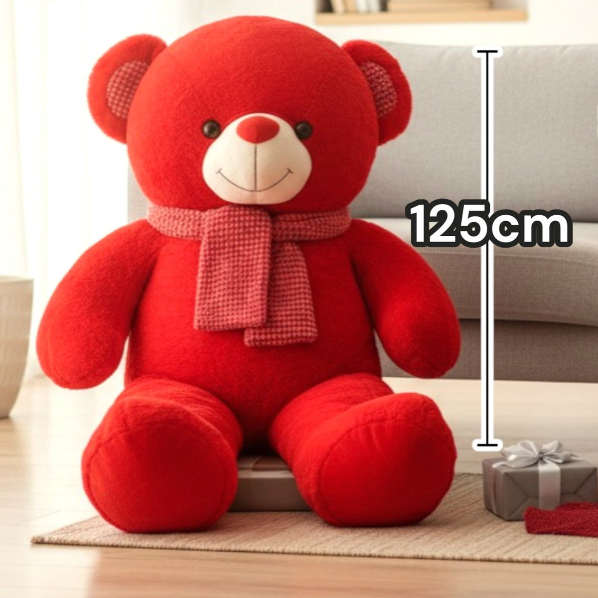 Red teddy bear seated facing forward with a pink scarf and checked ear patches
