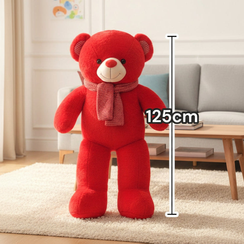 Bright red teddy bear standing with a soft pink knitted scarf around its neck