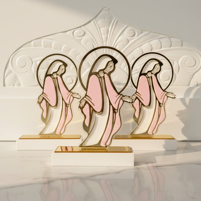 Three acrylic Virgin Mary panels with gold halo rings on white blocks in sunlight