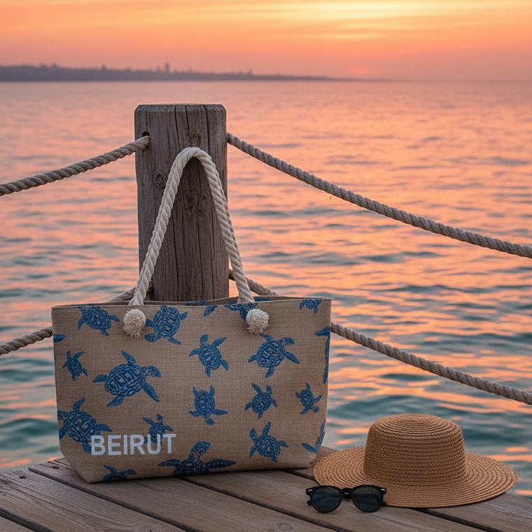 Beach bag with turtle pattern and 'Beirut' text on a sandy beach with ocean in the background