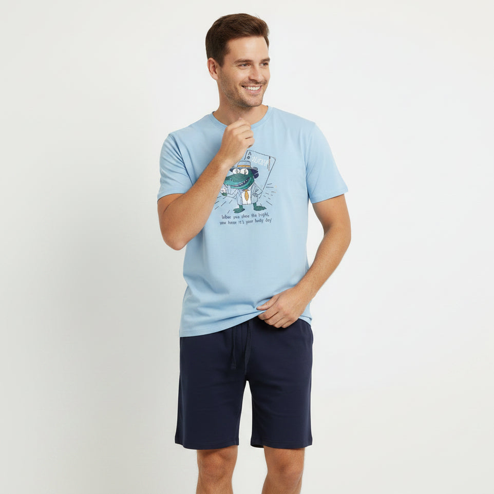 Light blue t-shirt with a graphic design and black shorts on a tiled floor.