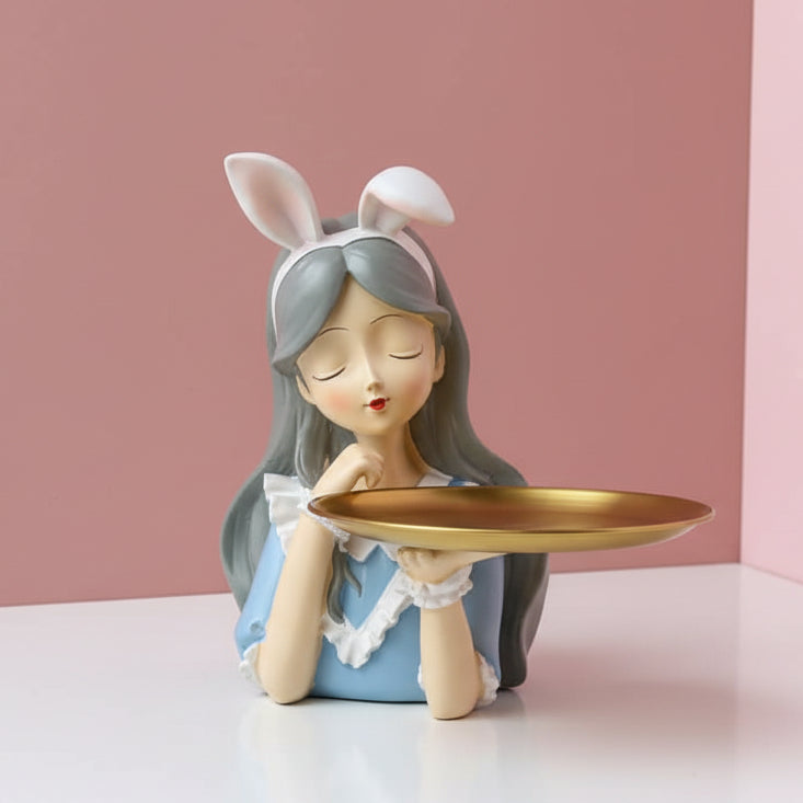 White bunny ears with pink linings above a powder blue dress and an empty gold tray