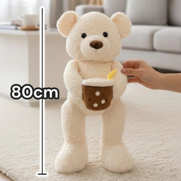 Cream curly teddy bear holding a boba cup plush beside an 80cm measuring line