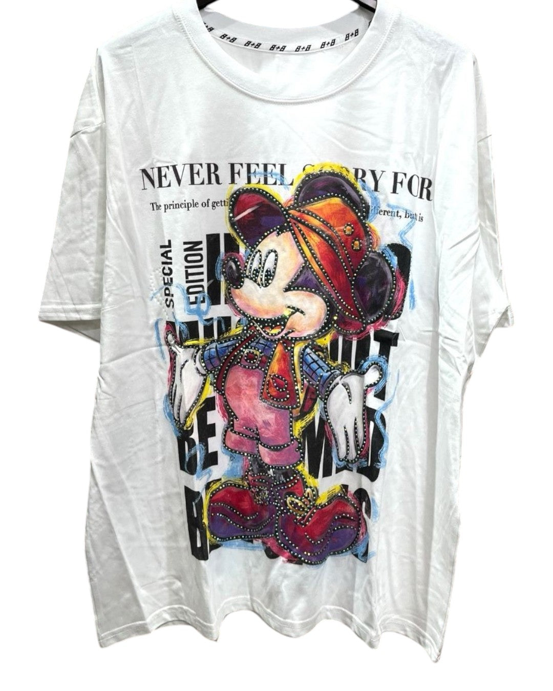 White oversized tshirt with a graphic of Mickey Mouse in a colorful outfit, with text on the shirt