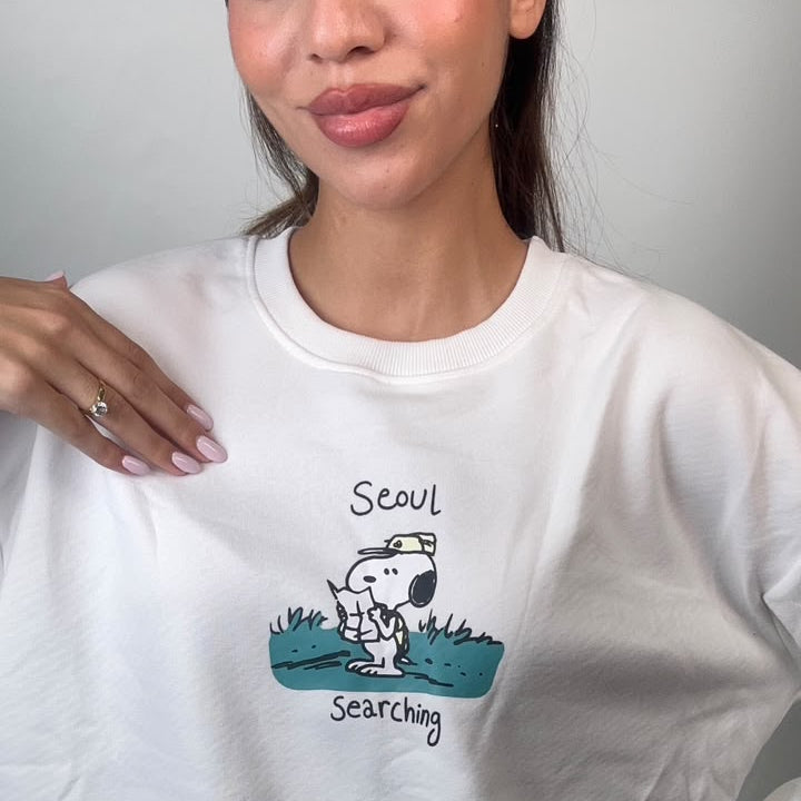 Close up of the teal puppy scout graphic on the chest of a white sweatshirt