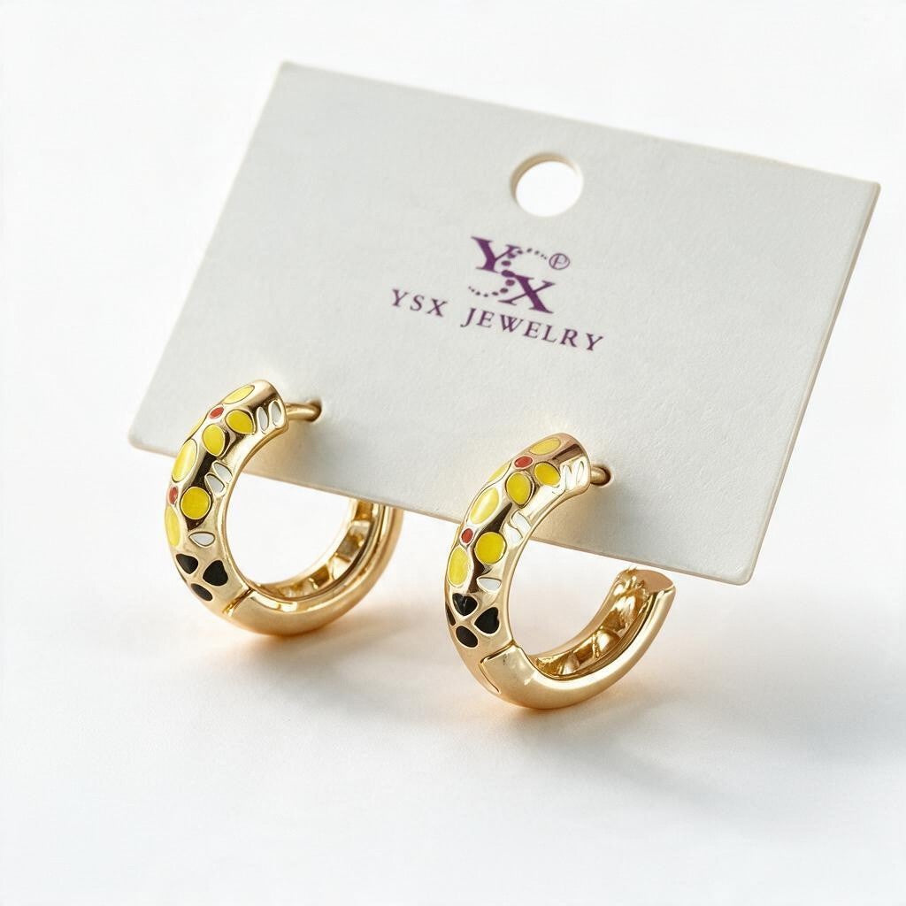Pair of chunky gold tone C hoops with yellow enamel flowers on a white display card