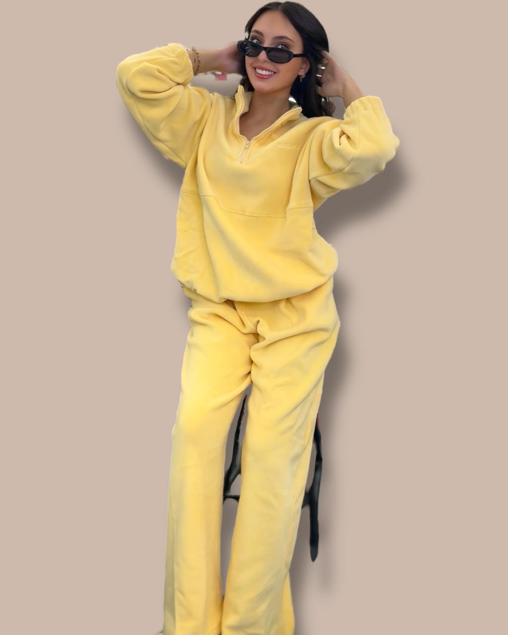 Person wearing a yellow lounge set against a beige background