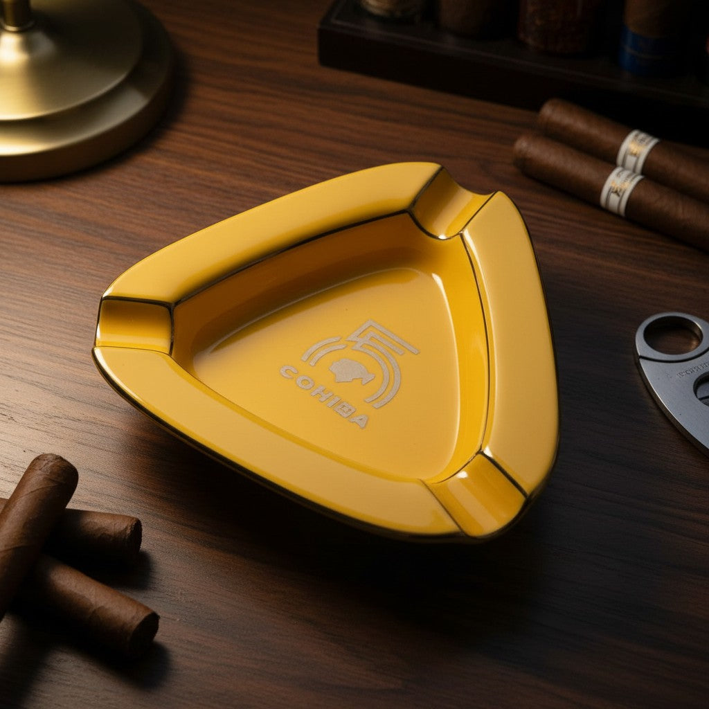 Yellow triangle ceramic cigar ashtray with three corner rests and a thin gold rim