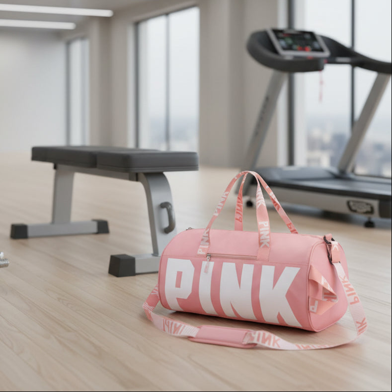 Pink duffel bag with 'PINK' branding on a gray background
