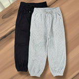 Black and grey sweatpants on a wooden surface